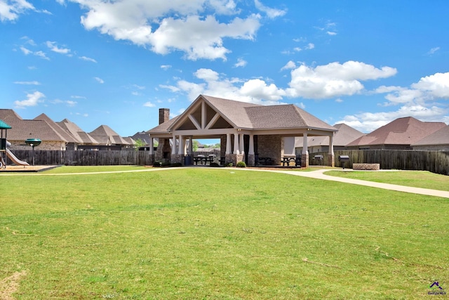 craftsman house with a gazebo, a chimney, fence, a playground, and a front lawn