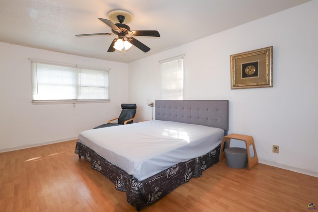 bedroom with wood finished floors, ceiling fan, and baseboards