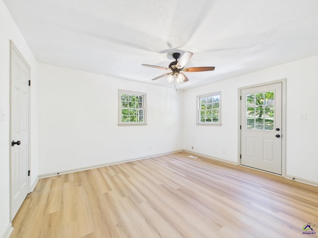 spare room with light wood-style flooring, ceiling fan, and baseboards
