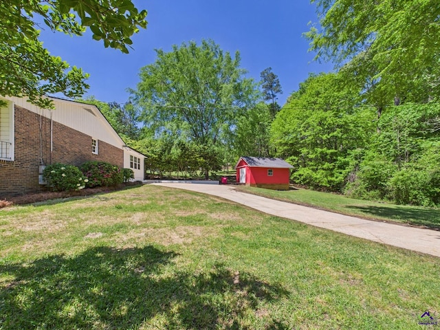 view of yard featuring concrete driveway and an outbuilding