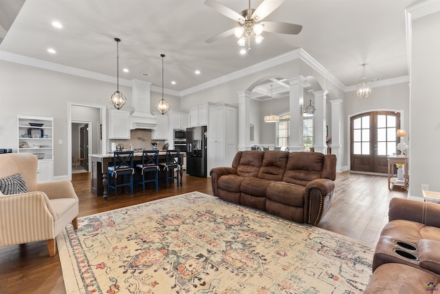 living area with decorative columns, arched walkways, recessed lighting, and ceiling fan