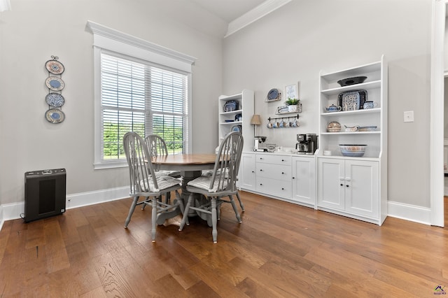 dining area featuring baseboards, ornamental molding, and wood finished floors
