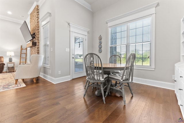dining area with crown molding, baseboards, and wood finished floors