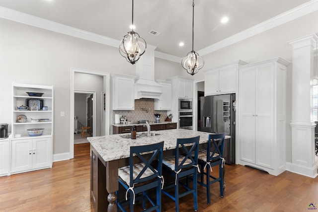 kitchen featuring wood finished floors, visible vents, a sink, and appliances with stainless steel finishes