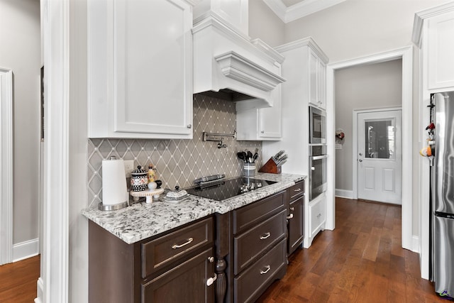kitchen with premium range hood, appliances with stainless steel finishes, white cabinetry, and dark brown cabinetry
