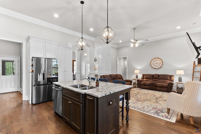 kitchen featuring dark brown cabinetry, dark wood-style flooring, appliances with stainless steel finishes, ceiling fan with notable chandelier, and a sink