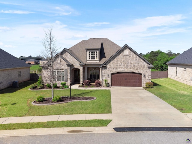 french country home featuring concrete driveway, a front lawn, brick siding, a garage, and fence