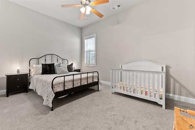 carpeted bedroom with visible vents, baseboards, and ceiling fan
