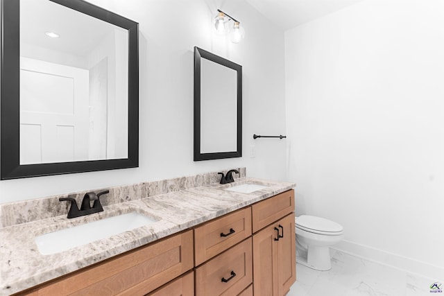 bathroom with marble finish floors, toilet, double vanity, and baseboards