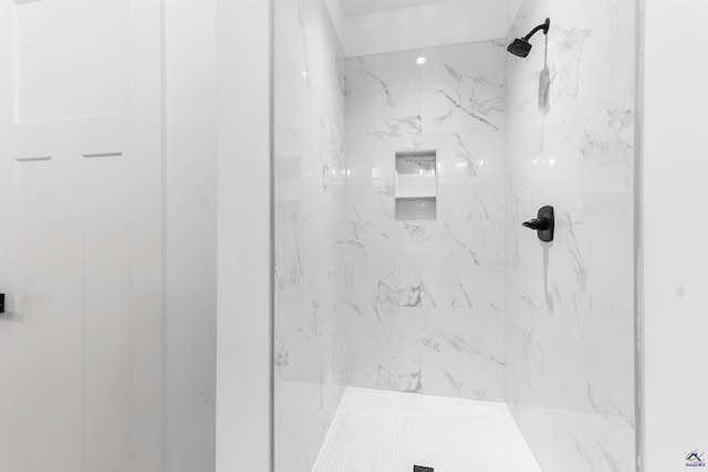 bathroom featuring a marble finish shower