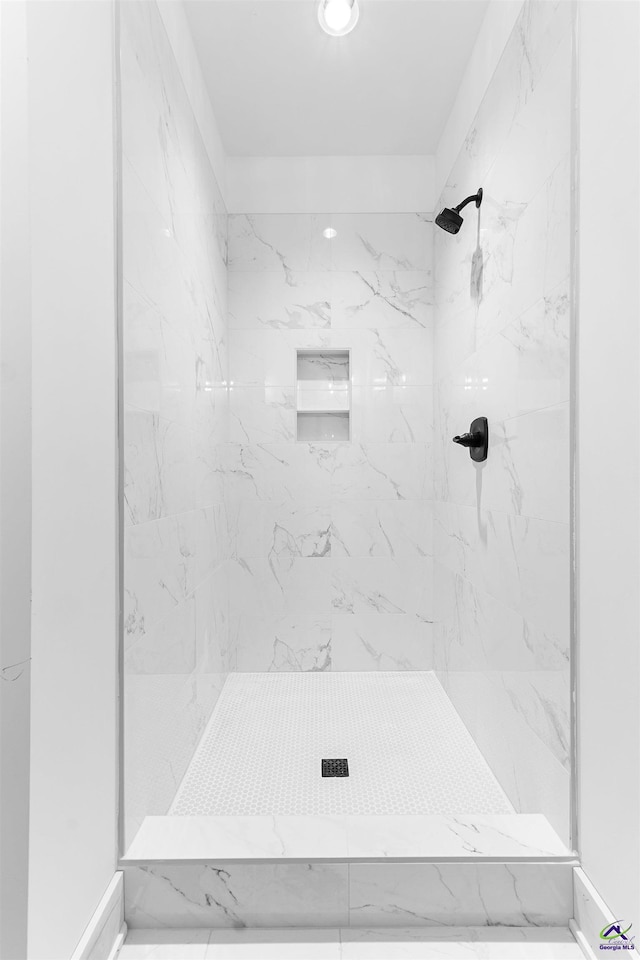full bath featuring a marble finish shower