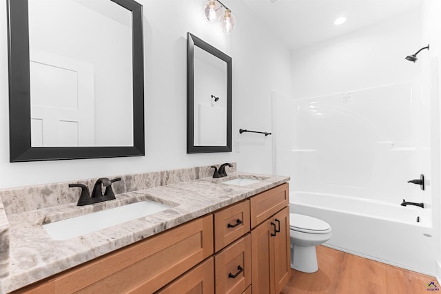 bathroom with wood finished floors, double vanity, toilet, shower / tub combination, and recessed lighting