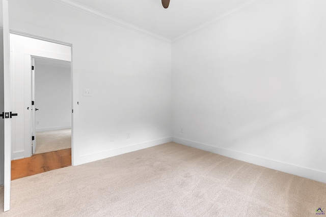 spare room with carpet flooring, crown molding, baseboards, and ceiling fan