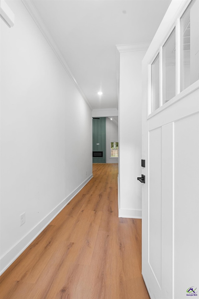 corridor featuring ornamental molding, baseboards, light wood finished floors, and recessed lighting