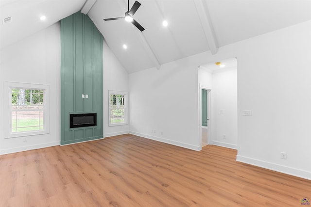 unfurnished living room featuring high vaulted ceiling, a ceiling fan, light wood-type flooring, a large fireplace, and beamed ceiling