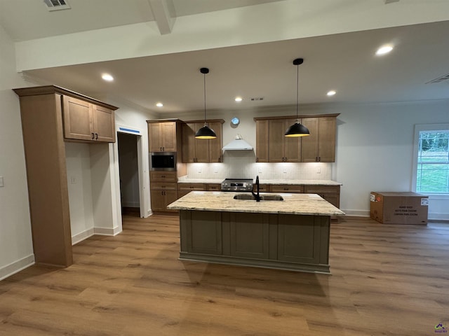 kitchen with appliances with stainless steel finishes, a sink, decorative backsplash, wood finished floors, and recessed lighting