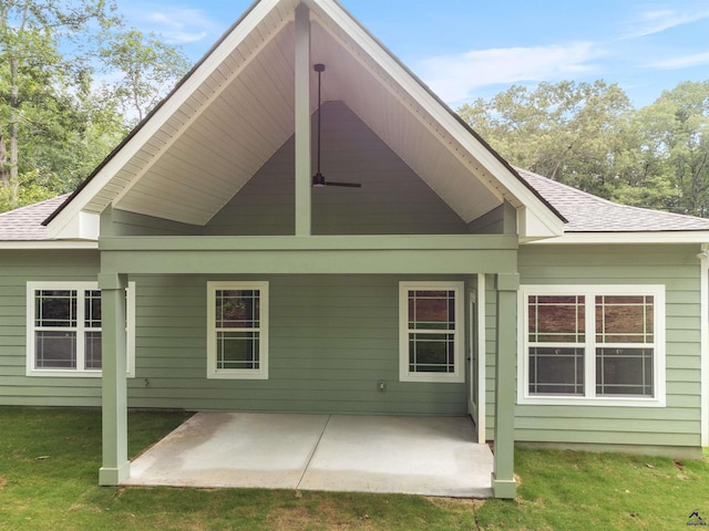 rear view of property featuring a patio area, roof with shingles, and a lawn