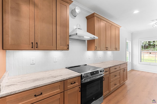 kitchen with electric range, ornamental molding, light wood-style flooring, decorative backsplash, and light stone countertops