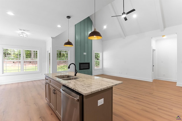 kitchen with a sink, dishwasher, light wood finished floors, high vaulted ceiling, and open floor plan