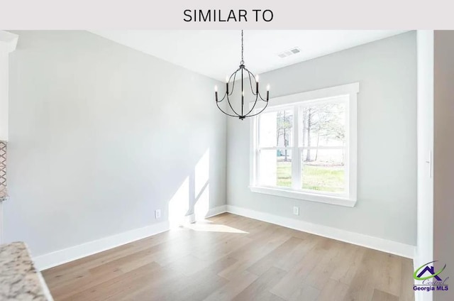 104 Reedy Ct, Perry, GA 31069 - unfurnished dining area with a chandelier, wood finished floors, and baseboards