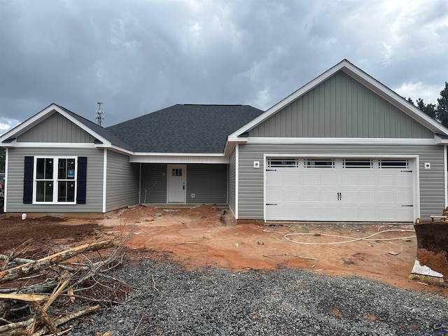 view of front of home featuring a garage, a shingled roof, and board and batten siding