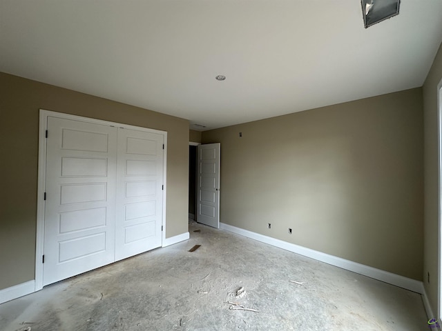 unfurnished bedroom with baseboards, a closet, and unfinished concrete floors