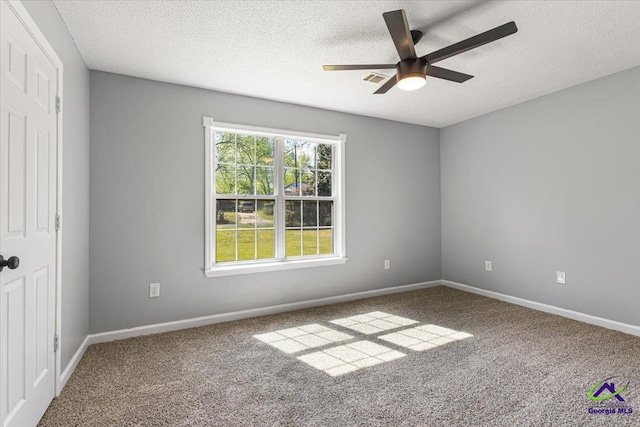 spare room with carpet, a textured ceiling, baseboards, and ceiling fan