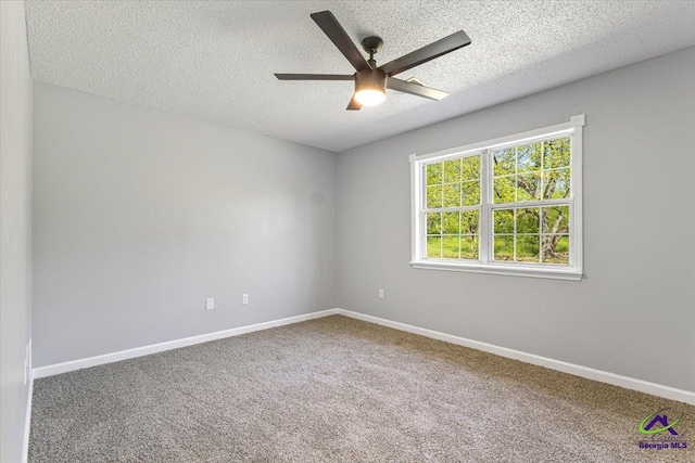 carpeted spare room with a ceiling fan, baseboards, and a textured ceiling