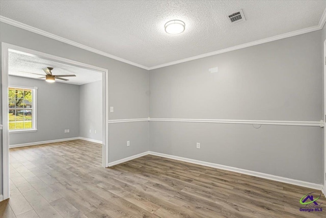 spare room featuring ceiling fan, wood finished floors, a textured ceiling, and visible vents