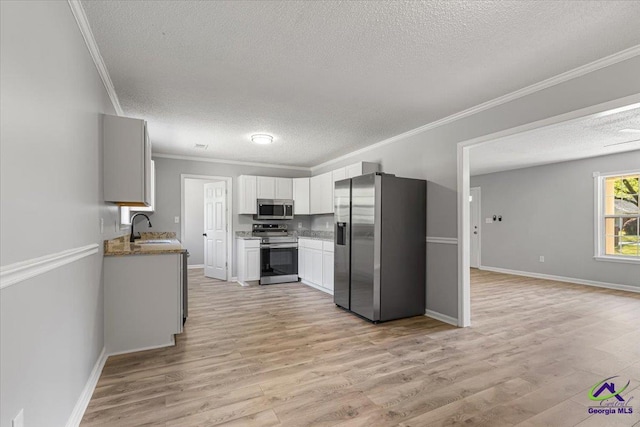 kitchen featuring ornamental molding, appliances with stainless steel finishes, and a textured ceiling