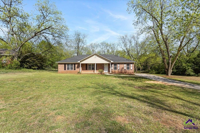 ranch-style home featuring covered porch, a front yard, and concrete driveway