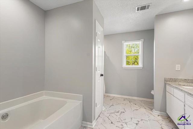 bathroom featuring a bath, baseboards, visible vents, and marble finish floor