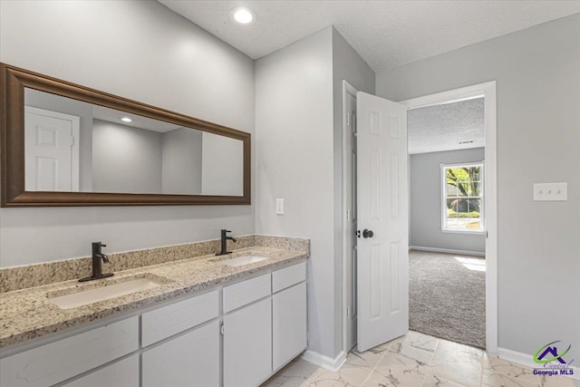 bathroom featuring marble finish floor, baseboards, and a sink