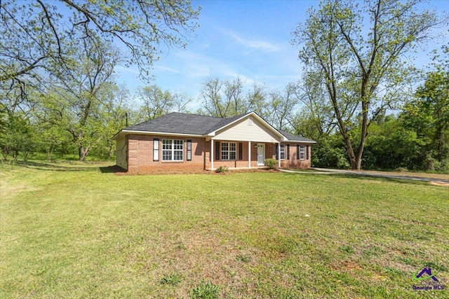 ranch-style home featuring brick siding, a front yard, and covered porch
