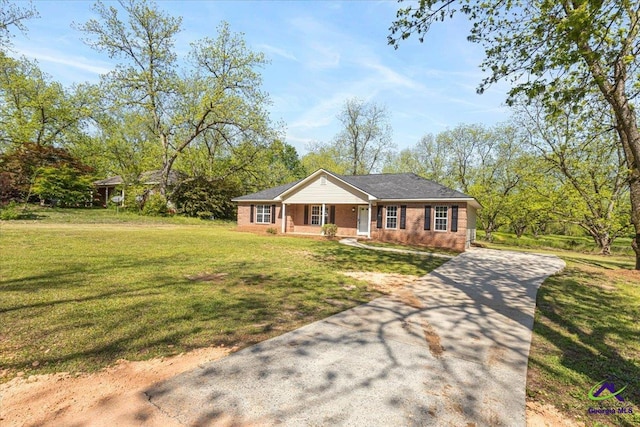 ranch-style house with brick siding, covered porch, a front yard, and concrete driveway