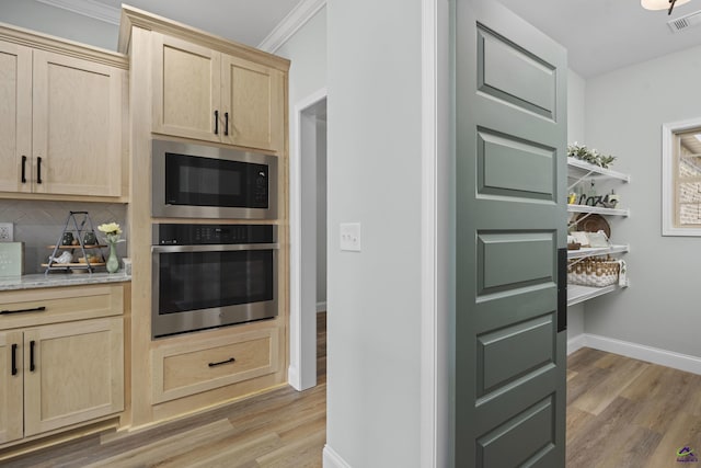 kitchen with built in microwave, stainless steel oven, light wood-type flooring, decorative backsplash, and light brown cabinets