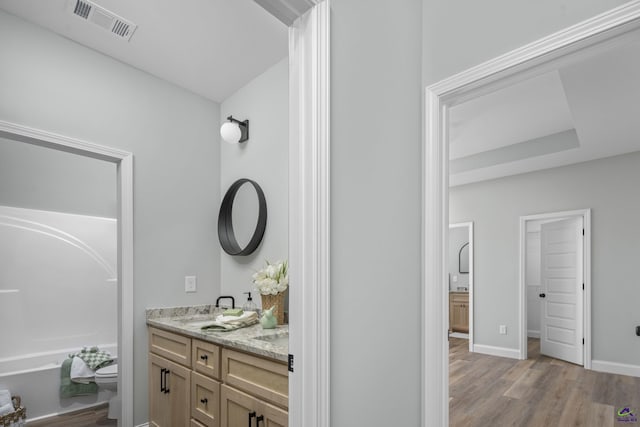 full bathroom with vanity, baseboards, toilet, visible vents, and wood finished floors