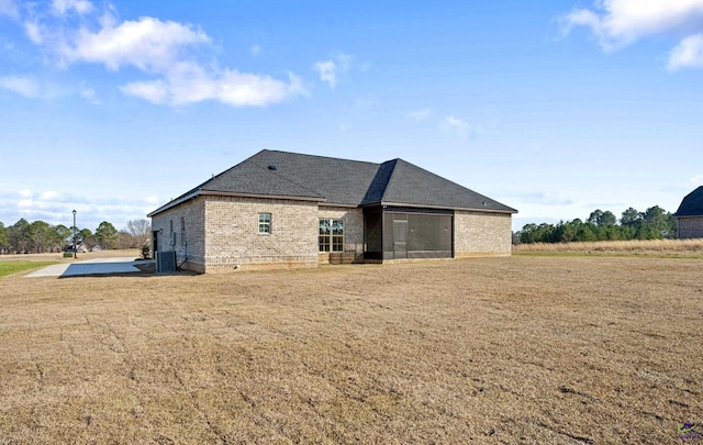 view of home's exterior with central air condition unit, a lawn, and brick siding