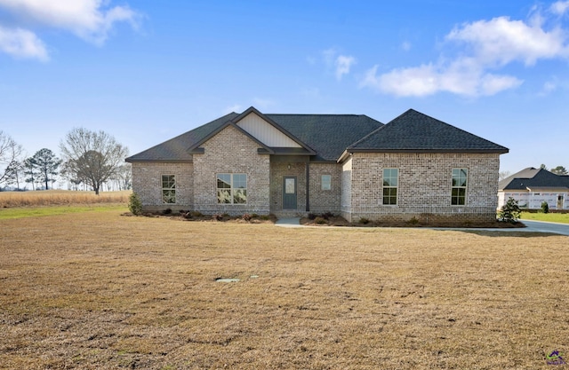 craftsman-style house featuring a front lawn, brick siding, and roof with shingles