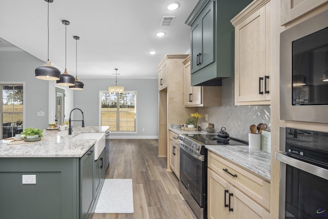 kitchen with crown molding, visible vents, baseboards, and stainless steel appliances