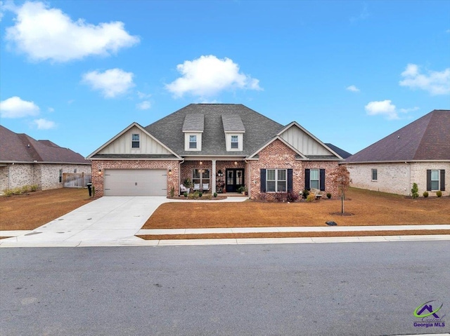 craftsman-style home with board and batten siding, brick siding, a front yard, and concrete driveway