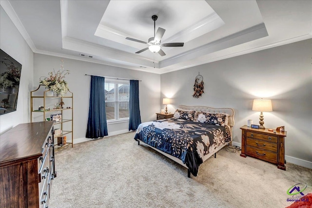 carpeted bedroom with a tray ceiling, visible vents, baseboards, ceiling fan, and ornamental molding