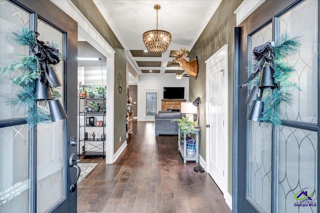 foyer entrance featuring dark wood-style floors, coffered ceiling, ornamental molding, baseboards, and ceiling fan with notable chandelier