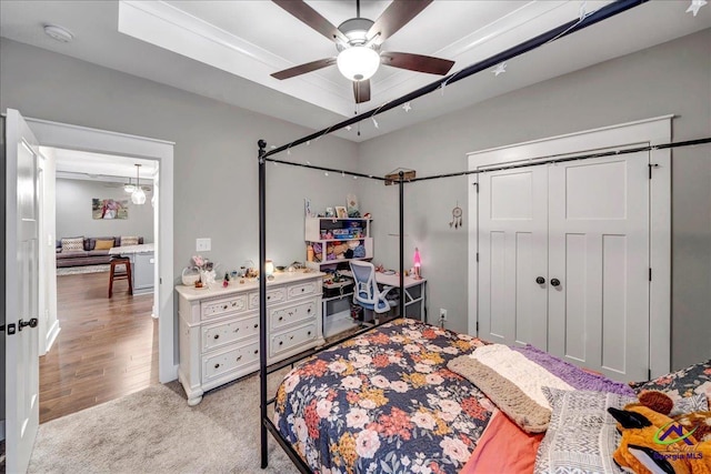 bedroom featuring light colored carpet, a ceiling fan, and a closet
