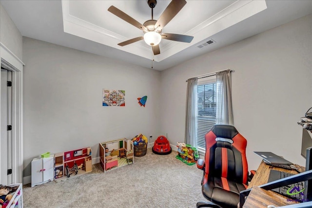 rec room with a raised ceiling, visible vents, a ceiling fan, baseboards, and carpet flooring