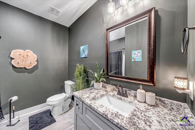 bathroom featuring vaulted ceiling, visible vents, toilet, vanity, and baseboards