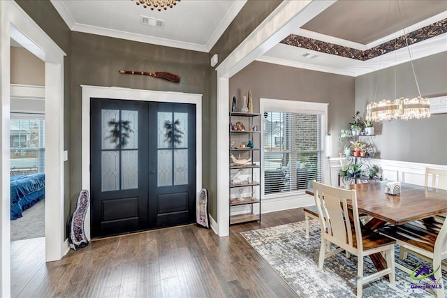 entrance foyer featuring crown molding, a chandelier, french doors, dark wood-type flooring, and visible vents
