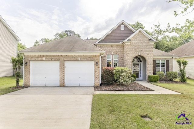 view of front of house with an attached garage, driveway, brick siding, and a front yard