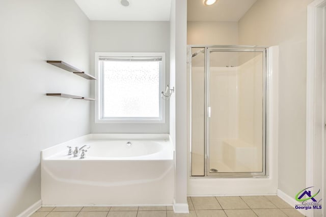 bathroom featuring tile patterned floors, a garden tub, baseboards, and a stall shower