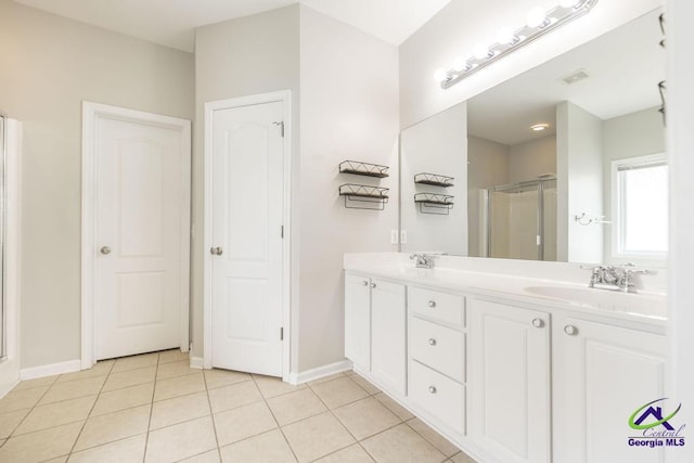 bathroom with a shower stall, tile patterned flooring, a sink, and visible vents